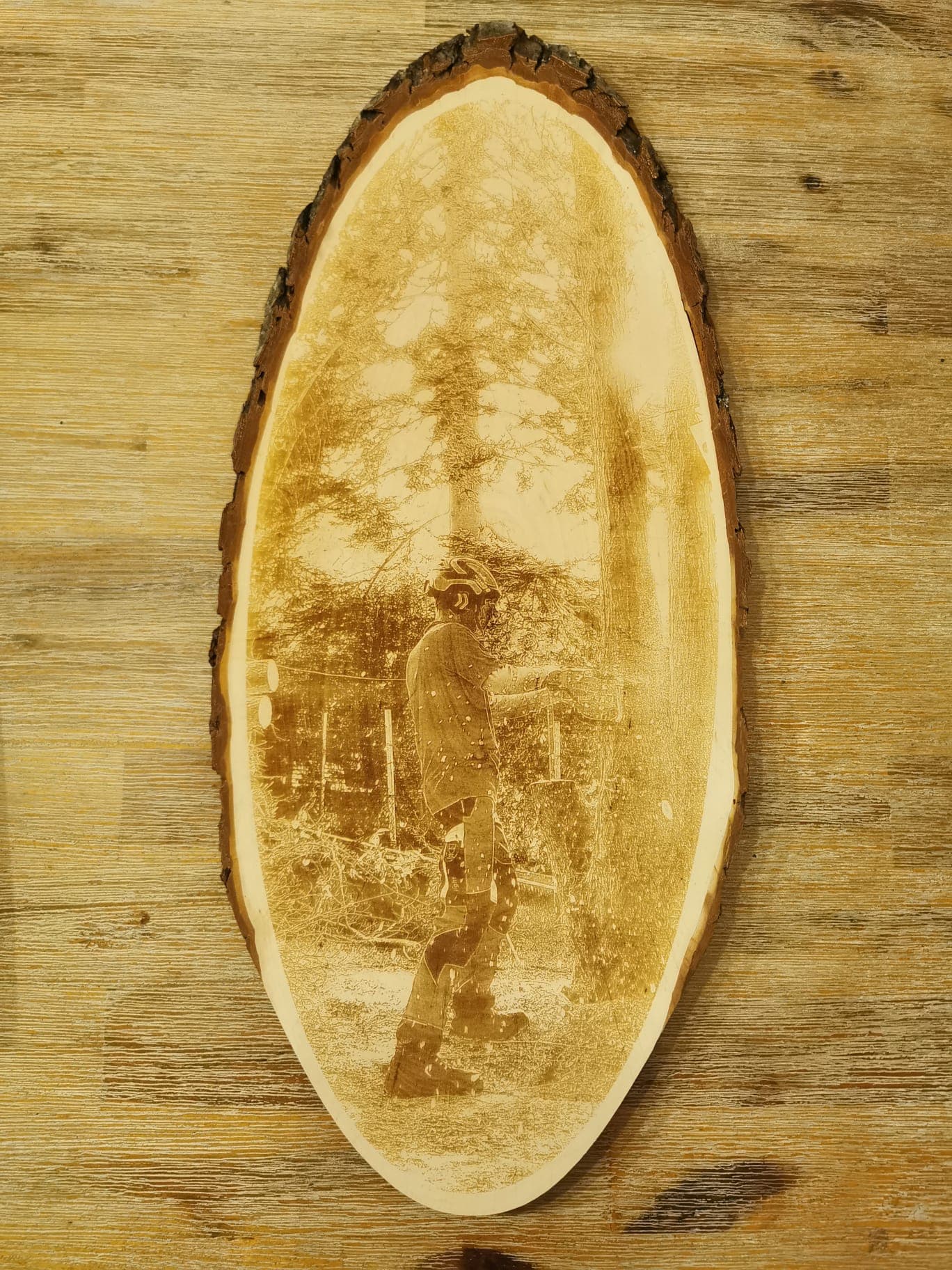 Elegantes Holzbild mit Gravur eines Mannes im Wald, umgeben von Natur, auf einer Holzscheibe, Rindenbrett mit rohem Rand, ideal für individuelle Dekoration, verfügbar bei Laserart Kevin Langer in Lübbecke.